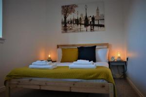 Un dormitorio con una cama con dos velas. en Peaceful, Lovely and Modern, Entire House, en Edimburgo