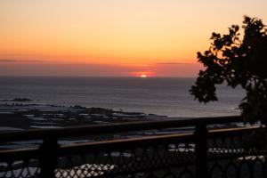 a sunset over the ocean from a balcony at Falasarna's Sunset Home in Falasarna