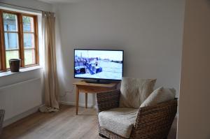 a living room with a television on a table and a chair at Landhaus Hohenfelde in Hohenfelde