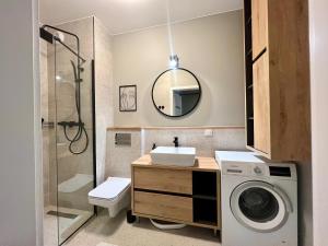 łazienka z umywalką i pralką w obiekcie Apartamenty Milionowa z garażem i klimatyzacją w Łodzi