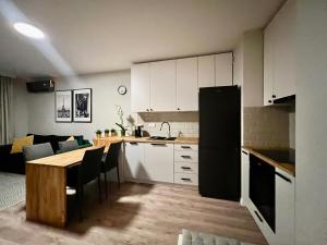 kuchnia i salon ze stołem i kanapą w obiekcie Apartamenty Milionowa z garażem i klimatyzacją w Łodzi