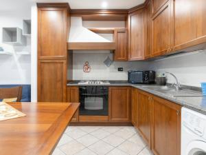 La cuisine est équipée de placards en bois et d'un four avec plaques de cuisson. dans l'établissement Apartment Ca' du Né by Interhome, à Albenga