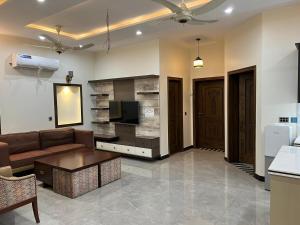 Brand new 3 bedrooms furnished, Upper floor في لاهور: غرفة معيشة بها أريكة وتلفزيون