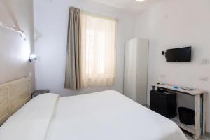una camera da letto bianca con un letto e una televisione di Brezza Marina a Tropea