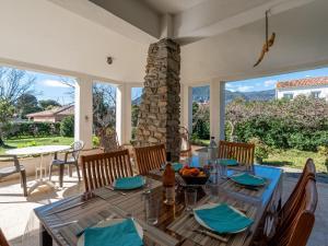 jadalnia ze stołem, krzesłami i oknami w obiekcie Holiday Home Tandjah - MNI137 by Interhome w mieście San-Nicolao