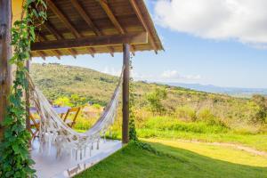 a hammock on the patio of a house with a view at Pousada Gaya in Carrancas
