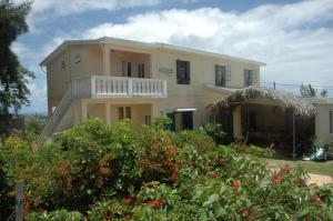 a house with a balcony and some plants at Rêve des Îles Guesthouse in Rodrigues Island