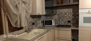 a kitchen with a sink and a microwave at HomeStory 2 via Idice 72 Pizzano BO in Casa Canovetta
