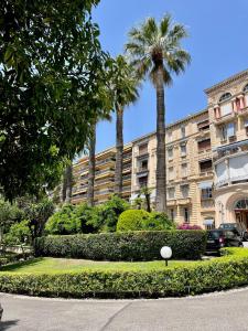 ein großes Apartmenthaus mit Palmen und Büschen in der Unterkunft NEWLY RENOVATED! Harbour View on Balcony Terrace in Cannes