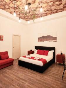 a bedroom with a bed and a red chair at I Tesori di Napoli in Naples