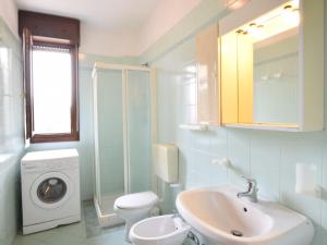 a bathroom with a sink and a washing machine at Apartment Acquamarina-3 by Interhome in Rosapineta