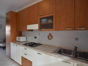 uma cozinha com armários brancos, um lavatório e um micro-ondas em Apartment Acquamarina-3 by Interhome em Rosapineta