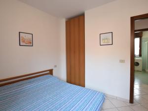 a bedroom with a bed and two pictures on the wall at Apartment Acquamarina-4 by Interhome in Rosapineta +13 photos