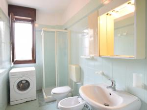 a bathroom with a sink and a washing machine at Apartment Acquamarina-4 by Interhome in Rosapineta