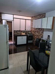 una cocina con armarios blancos y una mesa en una habitación en Amplio Departamento Residencial en La Molina, en Lima