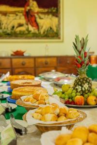 uma mesa coberta com pratos de pão e frutas em Eco Pousada Paraíso dos Coqueirais em Japaratinga