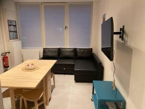 a living room with a black couch and a table at Eau de vie in Ostend
