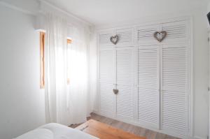 1 dormitorio con puertas blancas en el armario y ventana en Arroyo Bates Jaca, en Jaca