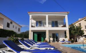 a group of lounge chairs next to a villa at LULA VILLA in Ayia Napa