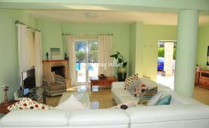 a living room with a white couch and a fireplace at LULA VILLA in Ayia Napa