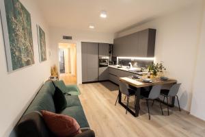 - un salon avec un canapé vert et une table dans l'établissement Moderno Appartamento 140 Bassano Centro, à Bassano del Grappa