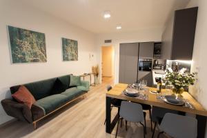 a living room with a green couch and a table at Moderno Appartamento 140 Bassano Centro in Bassano del Grappa