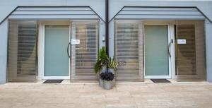 une rangée de portes dans un bâtiment avec des plantes dans l'établissement Moderno Appartamento 140 Bassano Centro, à Bassano del Grappa