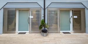 una fila di porte in un edificio con piante di Moderno Appartamento 140 Bassano Centro a Bassano del Grappa