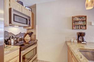 a small kitchen with a microwave and a sink at River Mtn Lodge W117C in Breckenridge +19 photos