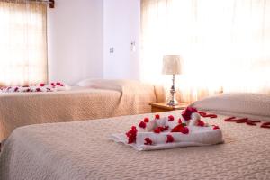 um quarto de hotel com duas camas com rosas na cama em Van Villa Guesthouse em Negril