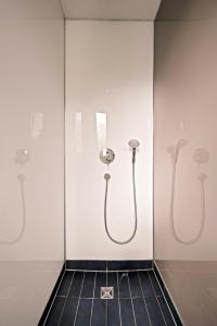ein Badezimmer mit drei Duschköpfen an einer Wand in der Unterkunft Wohnen in der alten Post - 5 min zum Ravensburger Spieleland in Meckenbeuren