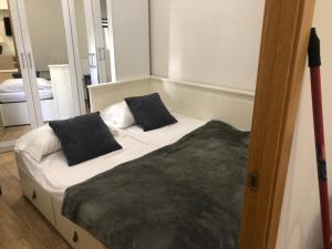 1 cama con 2 almohadas negras en una habitación en Aptos. Paniagua, en Córdoba