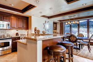 una cucina con armadi in legno e tavolo con sedie di Luxury Ski-In 3 Br Penthouse Inside Pines Lodge, Sleeps 10! Condo a Beaver Creek
