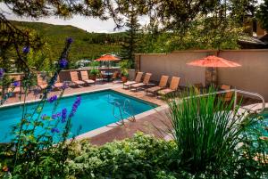 einen Pool mit Stühlen und Sonnenschirmen im Hof in der Unterkunft Luxury Ski-In 3 Br Penthouse Inside Pines Lodge, Sleeps 10! Condo in Beaver Creek