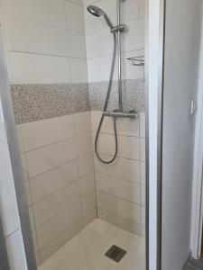 a shower with a shower head in a bathroom at Villa Hélios in Canet-en-Roussillon