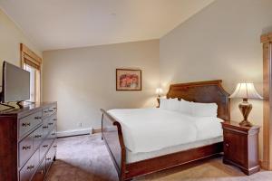 um quarto com uma cama branca e uma televisão em Mountain Thunder M204 em Breckenridge