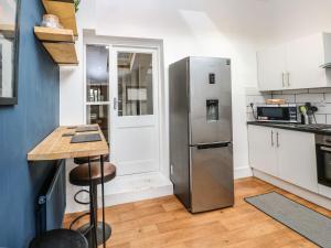una cucina con frigorifero in acciaio inossidabile e bancone di Hidden Door a Penzance