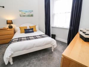 una camera con un letto bianco e una finestra di Hidden Door a Penzance