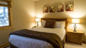een slaapkamer met een bed met 2 lampen en een raam bij Ski Trails 4113 in Truckee