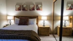 a bedroom with a bed and two lamps and a mirror at Ski Trails 4113 in Truckee