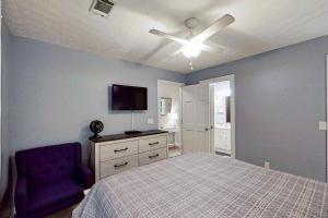um quarto com uma cama e uma cadeira roxa em Shipwatch Pointe II L-302 em Myrtle Beach