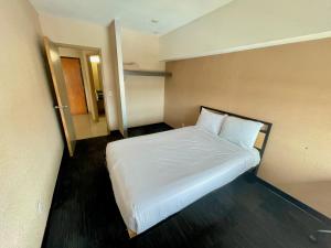 a bedroom with a white bed in a room at Residence & Conference Centre - Ottawa West in Ottawa