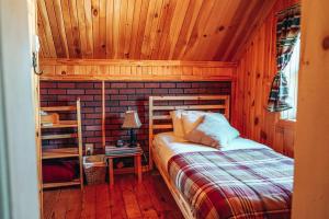 een slaapkamer met een bed en een houten muur bij Maison rustique entière & tout équipée in Saint Mathieu Du Parc