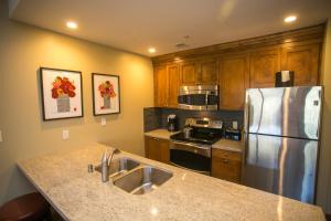 a kitchen with a stainless steel refrigerator and wooden cabinets at Fully Equipped in the Heart of Canyons Village in Park City