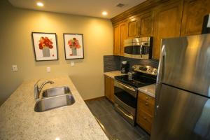 a kitchen with a stainless steel refrigerator and a sink at Fully Equipped in the Heart of Canyons Village in Park City