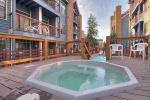 a hot tub on a deck with a balcony at River Mtn Lodge W301 in Breckenridge