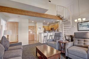 a living room with a couch and chairs and a kitchen at River Mtn Lodge E301 in Breckenridge