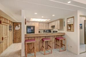 une cuisine avec des placards en bois et des tabourets de bar dans l'établissement VAB Antero 1205, à Breckenridge