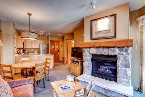 een woonkamer met een open haard en een eetkamer bij Dakota Lodge 8513 in Keystone