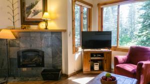 sala de estar con chimenea y TV en Ski Trails 4042, en Truckee